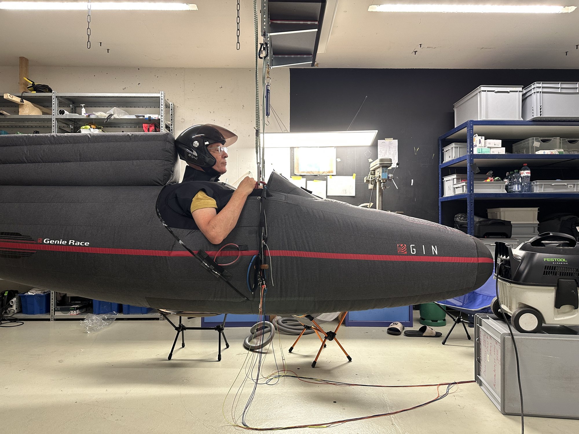 Jörg Korner in a GIN Genie Race pod harness, suspended in a workshop
